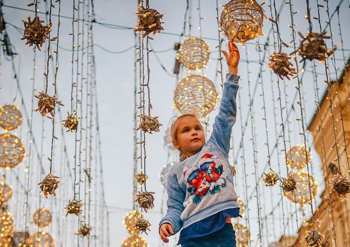 The little girl is grabbing a light bulb