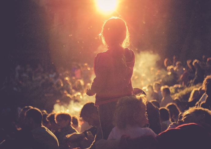The girl in the midst of the crowd is listening to the concert